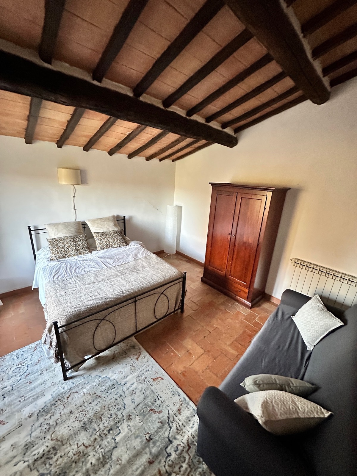 Sala del Capitolo — stanza con letto matrimoniale, armadio antico e divano, nell'Agriturismo Oria